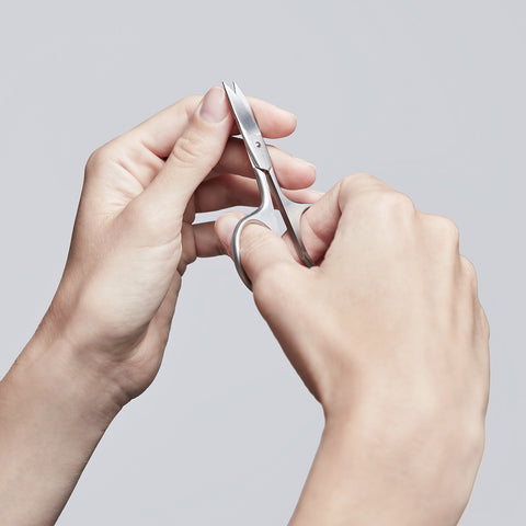 Anwendung einer ZWILLING Premium Nagelschere aus rostfreiem Edelstahl am linken Daumennagel.