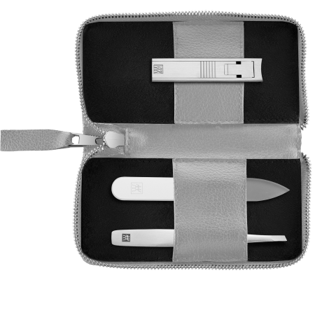 Geöffnetes ZWILLING Premium Apfelleder Set 3tlg. in grau mit Reißverschluss und essentiellen Pflegeinstrumenten (Kompakt-Nagelknipser, Glas-Nagelfeile und schräge Pinzette) in matt-silber.