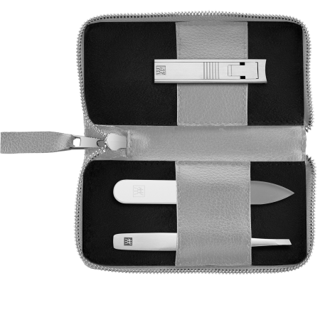 Geöffnetes ZWILLING Premium Apfelleder Set 3tlg. in grau mit Reißverschluss und essentiellen Pflegeinstrumenten (Kompakt-Nagelknipser, Glas-Nagelfeile und schräge Pinzette) in matt-silber.