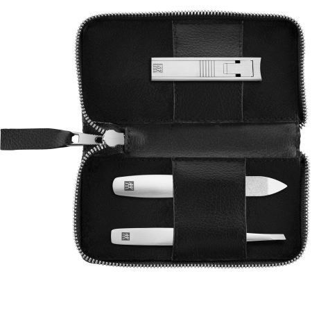 Geöffnetes ZWILLING Premium Apfelleder Set 3tlg. in schwarz mit essentiellen Pflegeinstrumenten (Kompakt-Nagelknipser, Saphir-Nagelfeile, schräge Pinzette) in matt-silber.