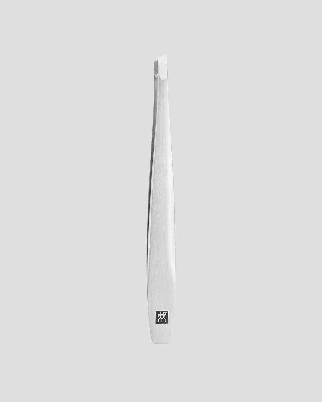 Abgewinkelte Pinzette aus mattiertem Edelstahl von ZWILLING Beauty vor grauem Hintergrund.