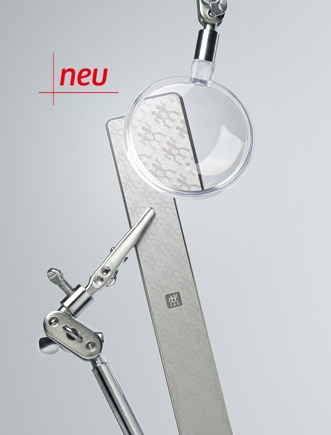 Die neue Premium-Edelstahl-Nagelfeile im exklusiven Zwilling-Design, das durch die Abbildung einer Lupe im Detail erkennbar ist.