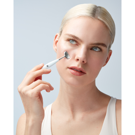 Anwendung des breiten Endes des ZWILLING Facial Pore Refiners an der rechten Wange, geführt mit der rechten Hand.