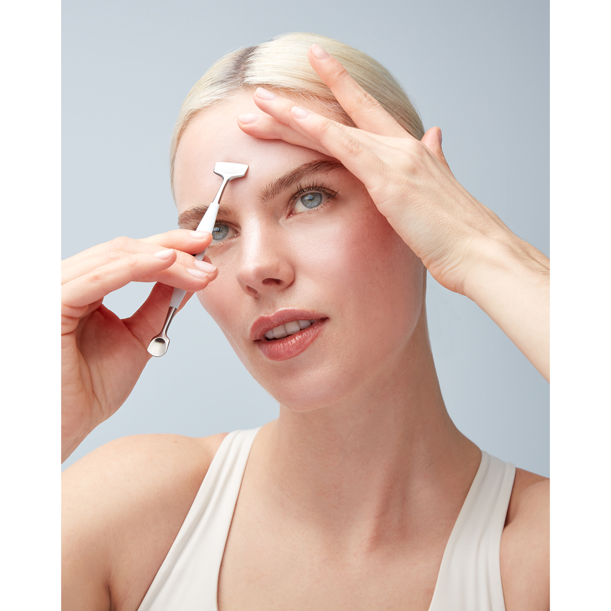 Anwendung des breiten Endes des ZWILLING Facial Pore Refiners an der Stirn, gehalten in der rechten Hand.