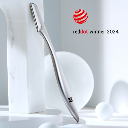 Darstellung des ZWILLING Premium Gesichtshaar-Rasierers inmitten von Marmorobjekten. Ausgezeichnet mit dem reddot winner award 2024.