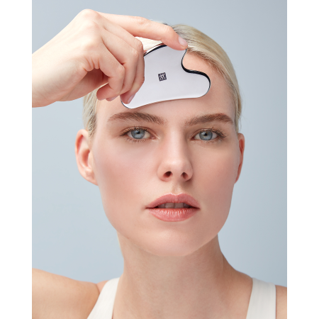 Anwendung des ZWILLING Premium Edelstahl-Gesichtsmassagers an der rechten Wange.