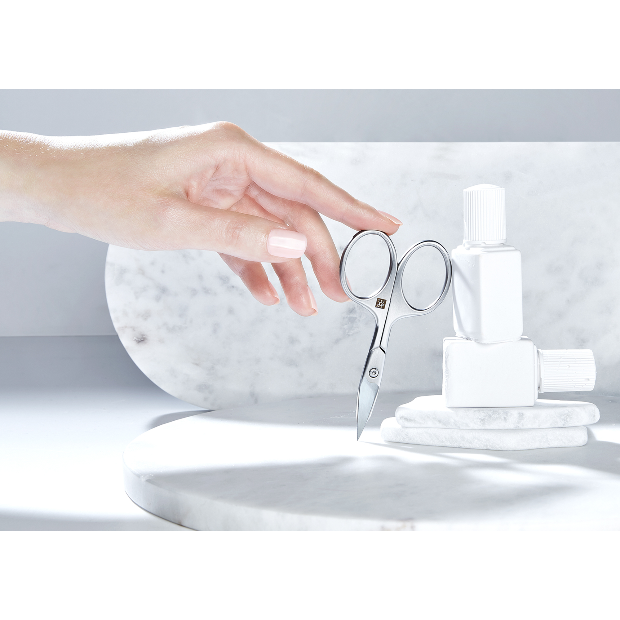 Sehr hochwertige Darstellung der ZWILLING Premium Nagel- und Nagelhautschere inmitten von artifiziellen Marmor- und Steinobjekten.