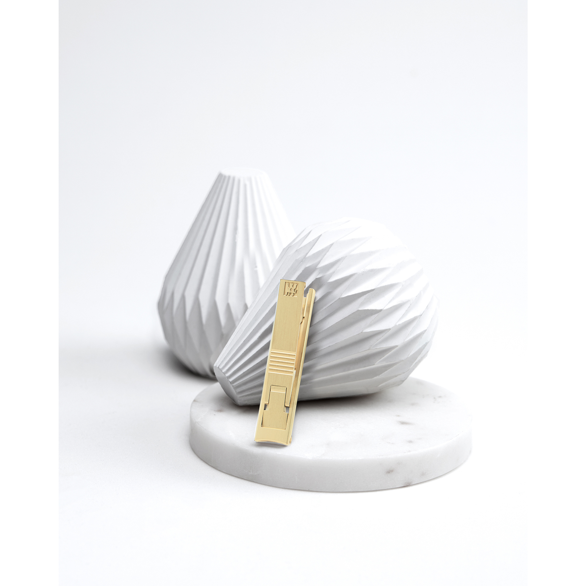 Darstellung des ZWILLING Premium Nagelknipsers in Gold inmitten von artifiziellen Betonobjekten.