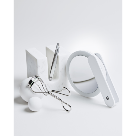 Darstellung des ZWILLING Premium LED-Kosmetikspiegels zusammen mit weiteren ZWILLING Produkten inmitten von artifiziellen Marmorobjekten.