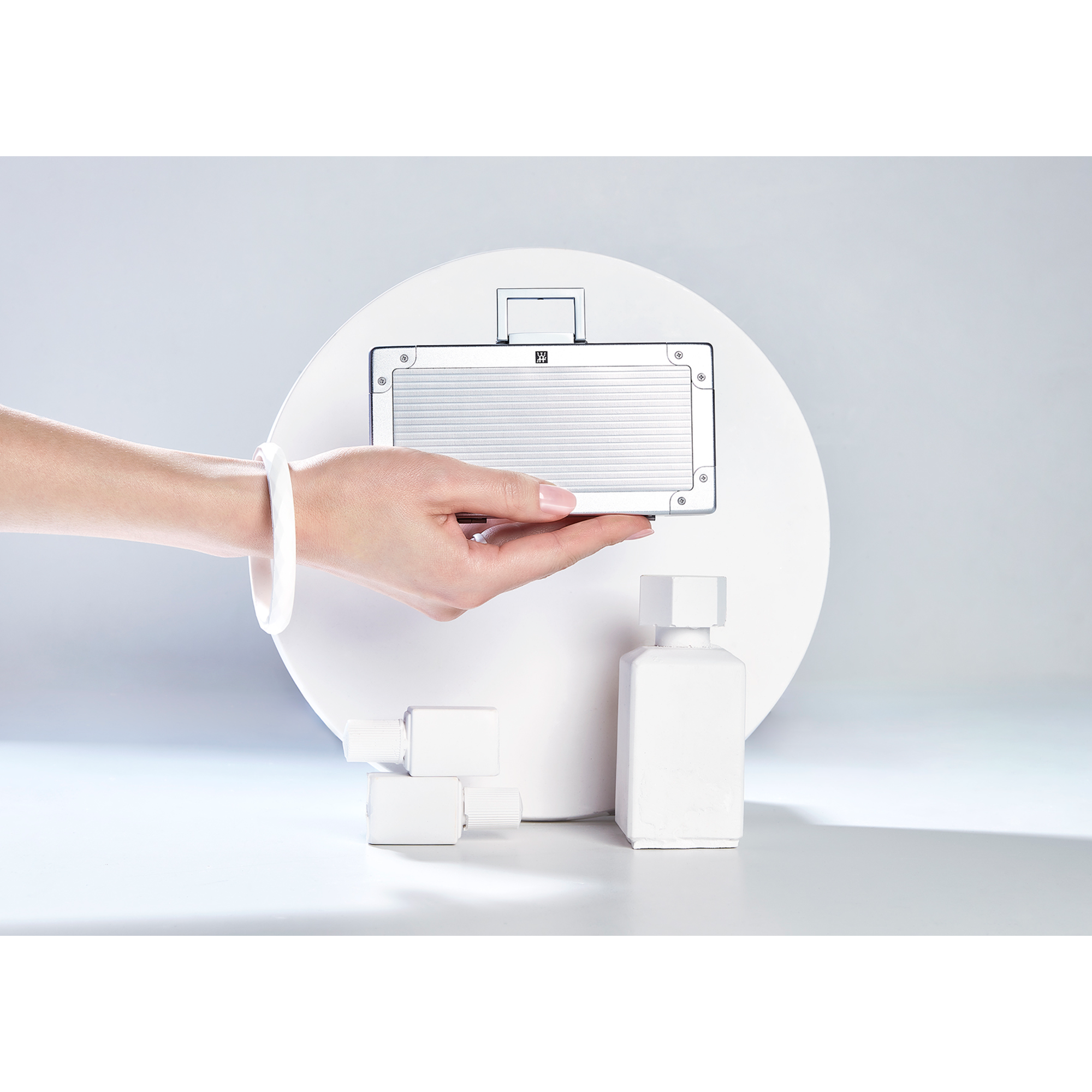 Darstellung eines ZWILLING Premium Maniküre Sets 5tlg. gehalten vor artifiziellen Betonobjekten.