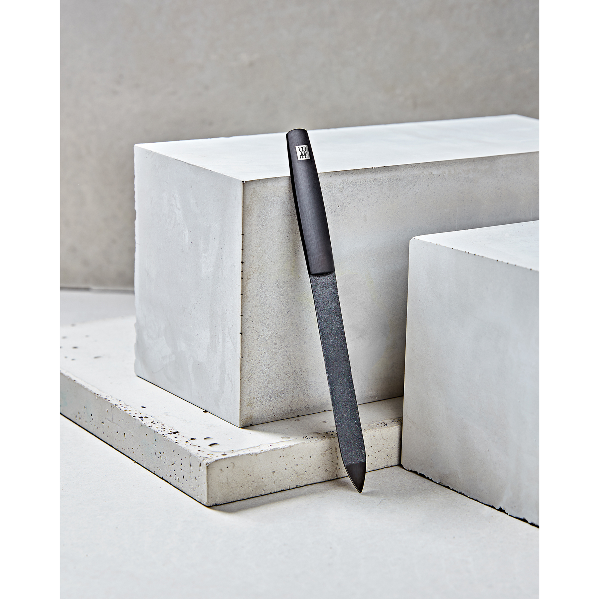 Sehr hochwertige Darstellung der ZWILLING Premium Saphir-Nagelfeile inmitten von Betonobjekten.