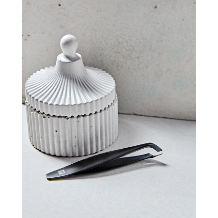 Darstellung des ZWILLING Premium Nagelhautschneiders in schwarz neben artifiziellen Betonobjekten.