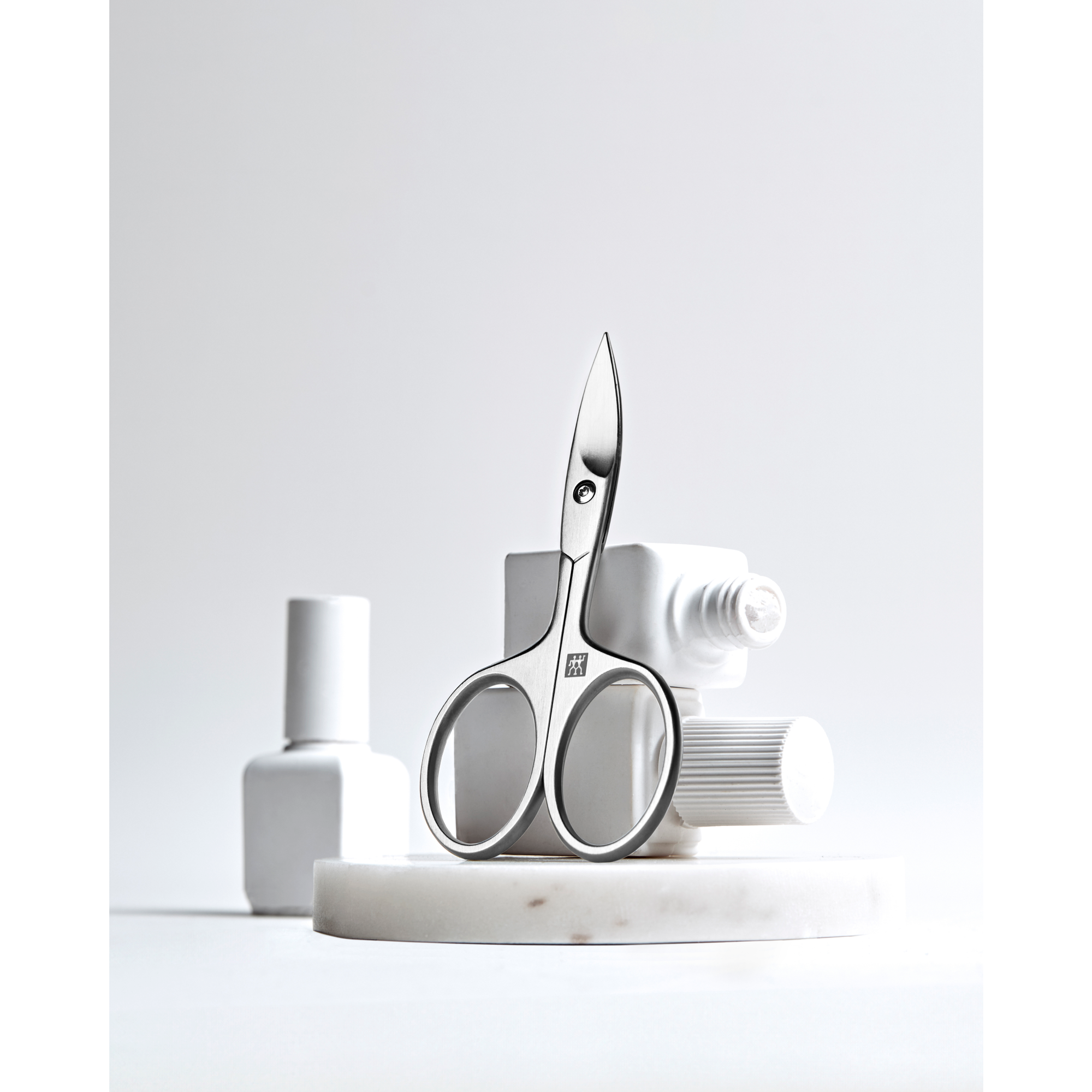 Sehr hochwertige Darstellung der ZWILLING Premium Nagelschere inmitten von artifiziellen Marmorobjekten.