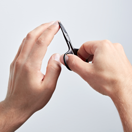Anwendung einer ZWILLING Premium Nagelschere in Schwarz am linken Zeige-Fingernagel.