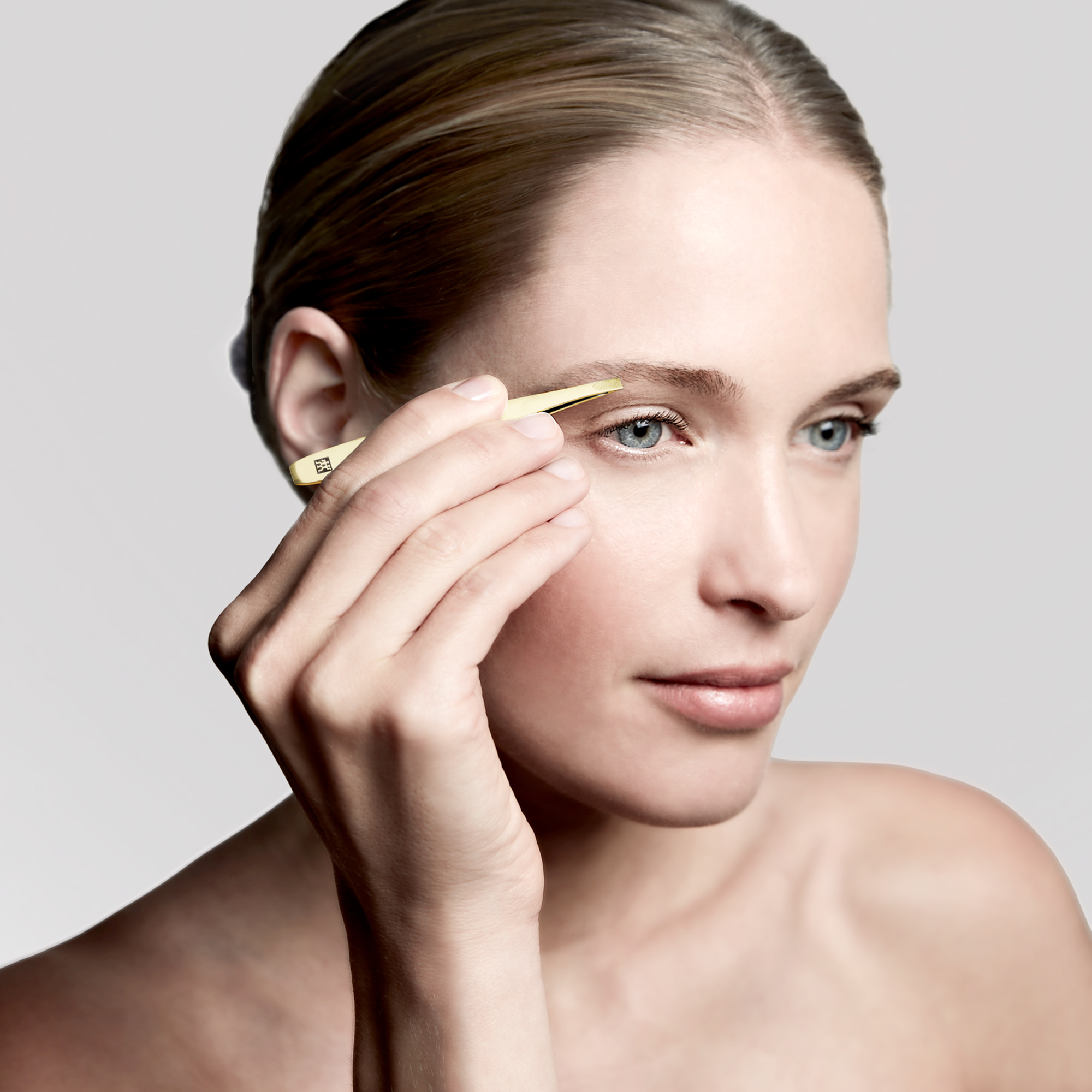 Anwendung der ZWILLING Premium schrägen Pinzette in Gold an der rechten Augenbraue.