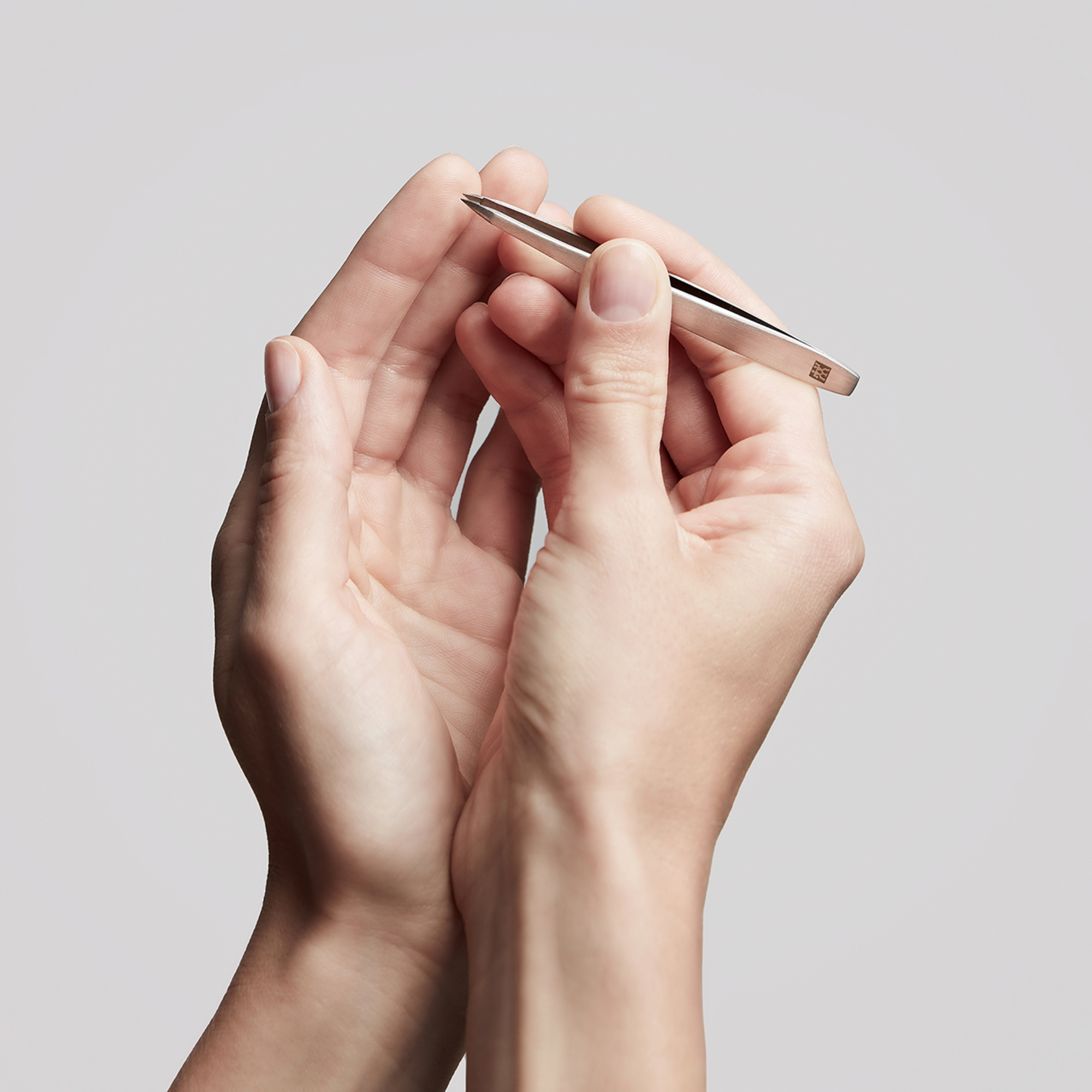 Anwendung der ZWILLING Premium spitzen Pinzette aus rostfreiem Edelstahl an der Fingerkuppe.