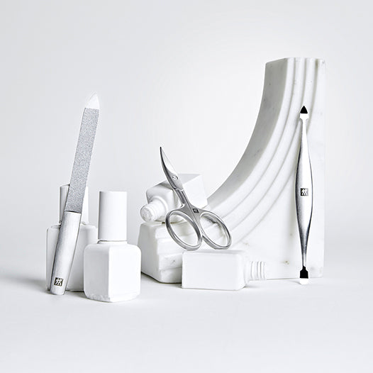 ZWILLING Produkte in Silber auf Keramik- und Marmorobjekten drapiert.