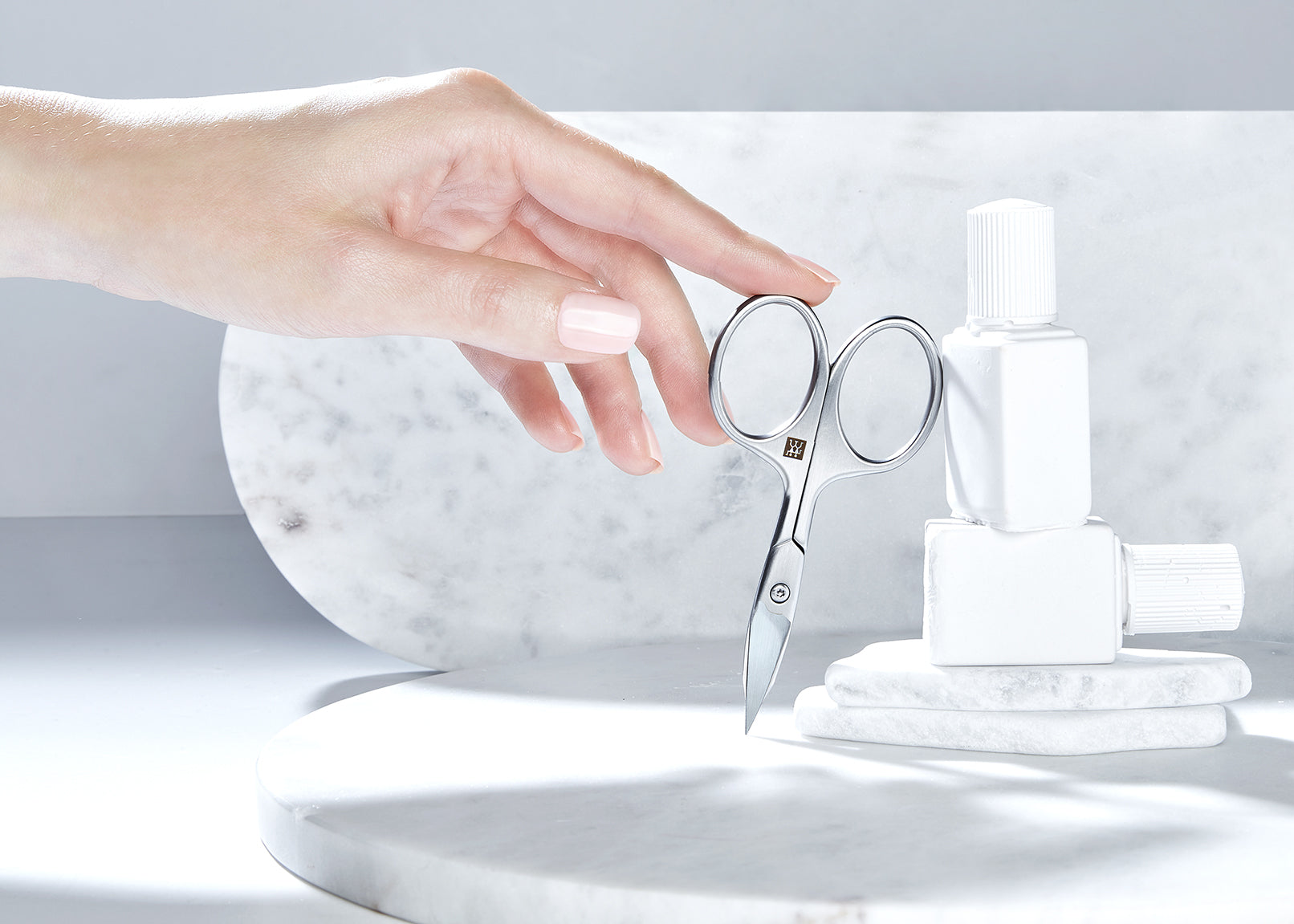 Sehr hochwertige Darstellung der ZWILLING Premium Nagel- und Nagelhautschere inmitten von artifiziellen Marmor- und Steinobjekten.