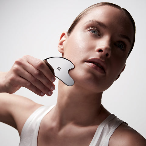 Anwendung des ZWILLING Premium Edelstahl-Gesichtsmassagers an der rechten Wange.
