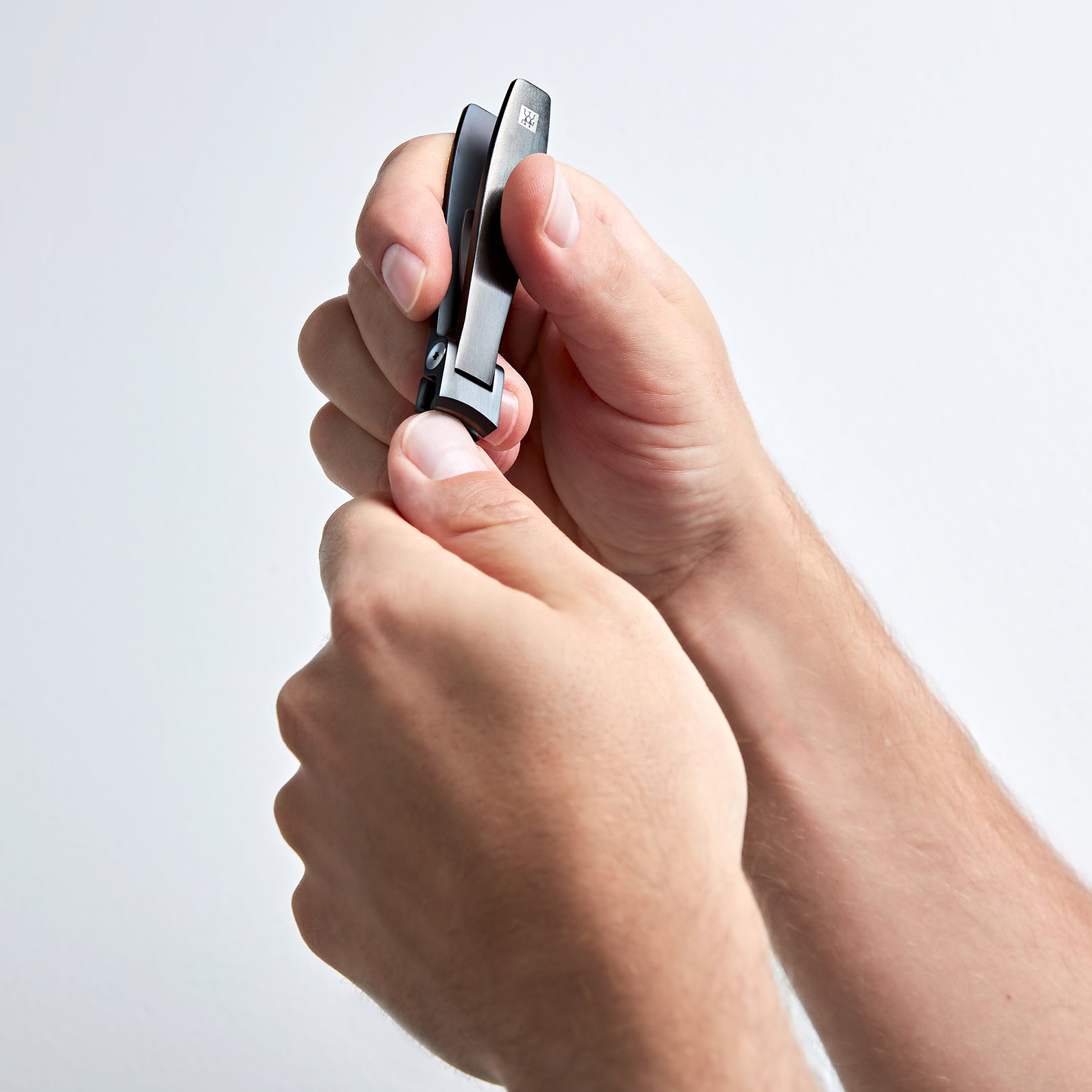 Anwendung eines ZWILLING Premium Nagelknipsers in schwarz am linken Daumennagel.