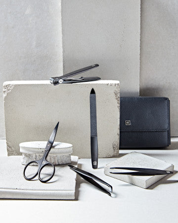 Darstellung eines ZWILLING Premium Maniküre Sets 5tlg. vor artifiziellen Betonobjekten.