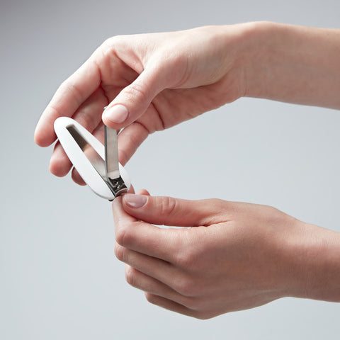 Anwendung eines ZWILLING Premium Nagelknipsers mit Nagelfang aus rostfreiem Edelstahl am linken Daumennagel.
