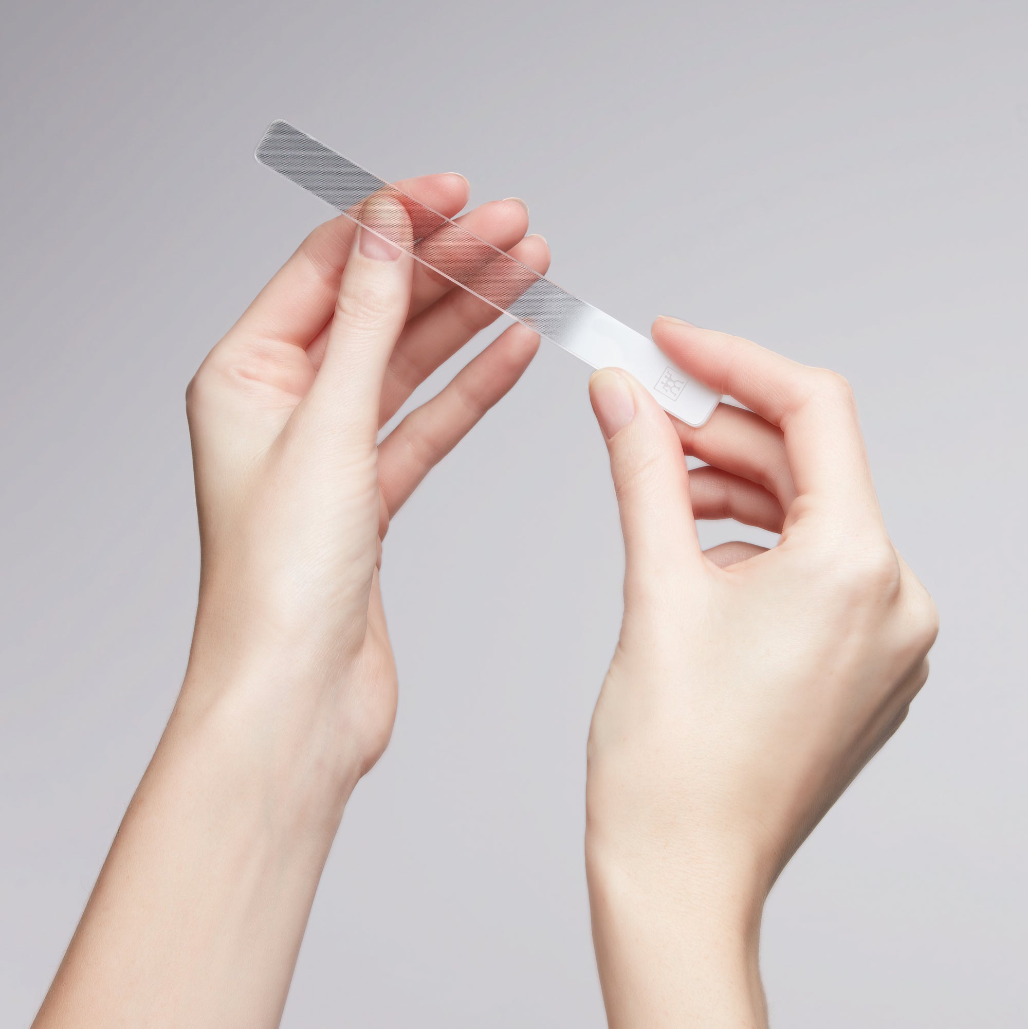 Anwendung eines ZWILLING Premium Glas-Nagelbuffers an dem linken Daumennagel.