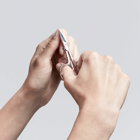 Anwendung einer ZWILLING Classic  Nagel- und Nagelhautschere aus rostfreiem Edelstahl  am linken Daumen Fingernagel.