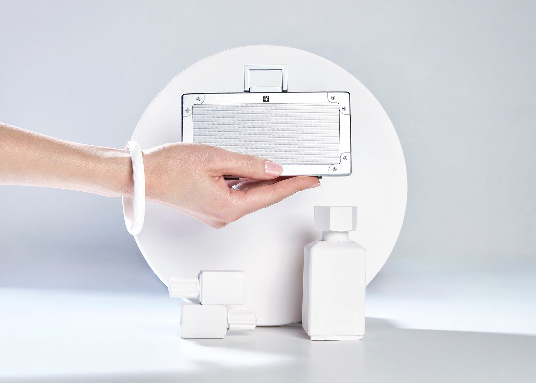 Darstellung eines ZWILLING Premium Maniküre Sets 5tlg. gehalten vor artifiziellen Betonobjekten.