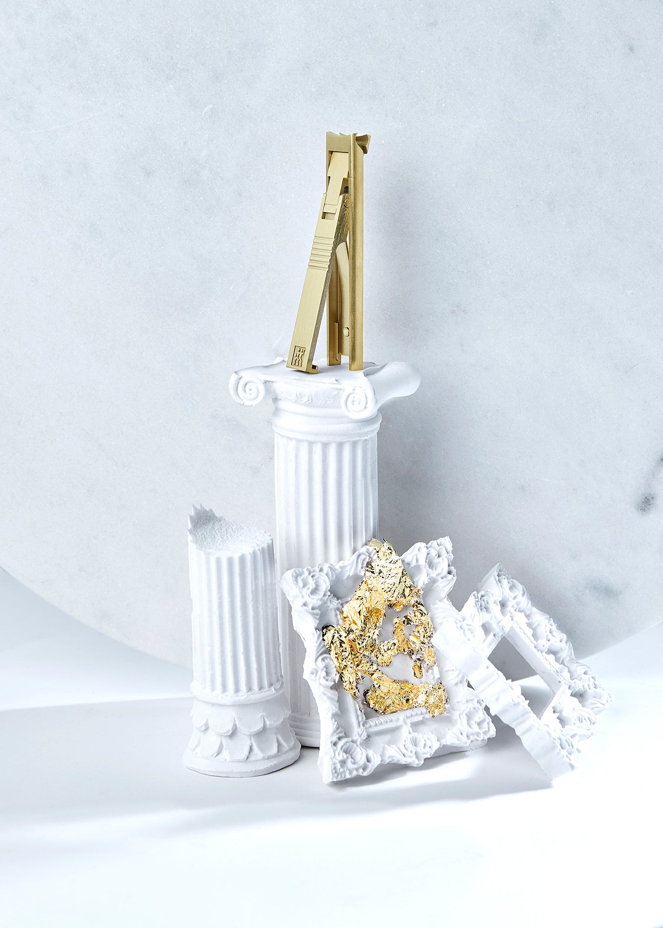 Darstellung des ZWILLING Premium Nagelknipsers in Gold inmitten von artifiziellen Betonobjekten.