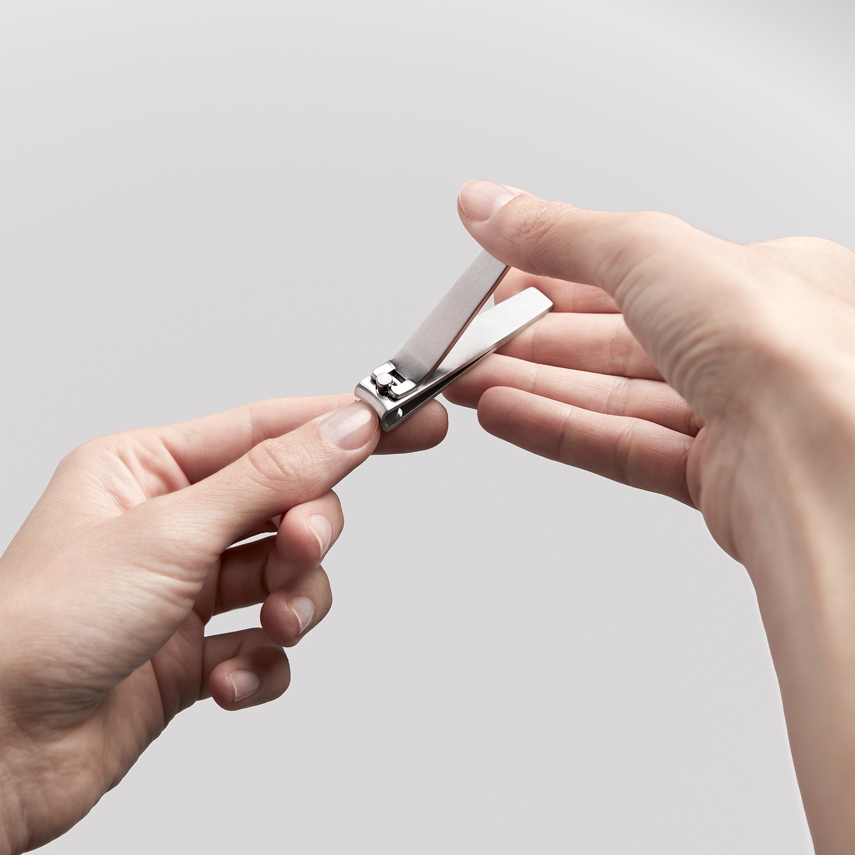 Anwendung eines ZWILLING Premium Nagelknipsers aus rostfreiem Edelstahl am linken Daumennagel.
